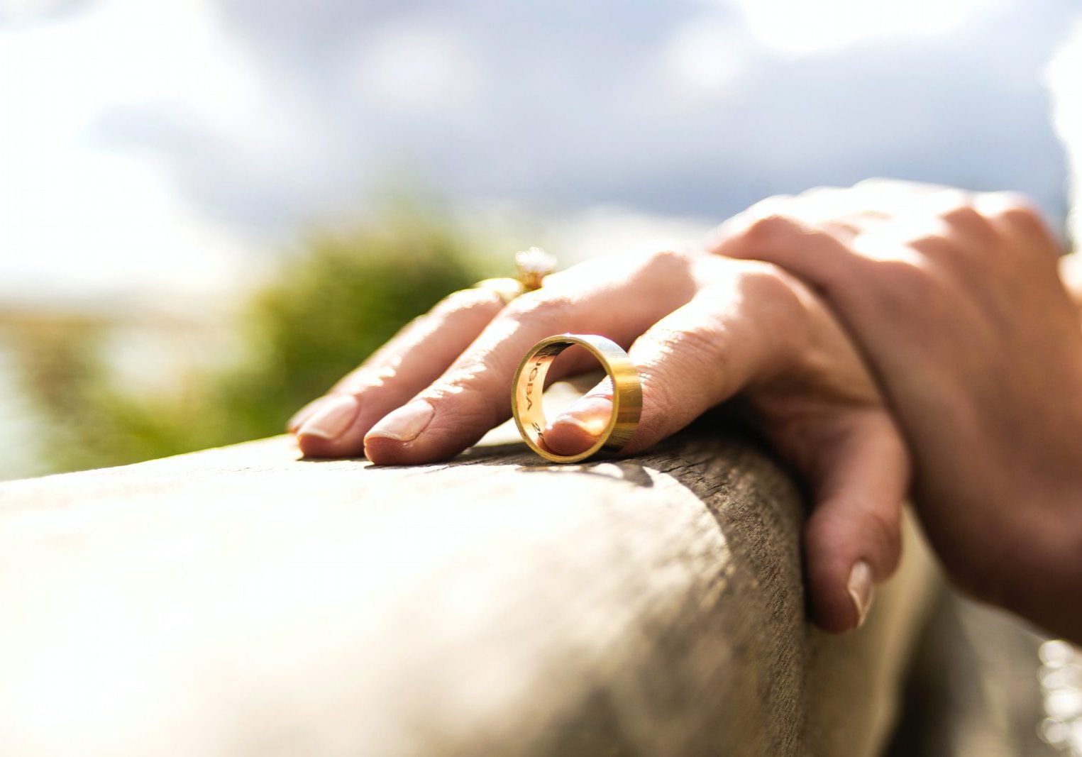person holding gold wedding band